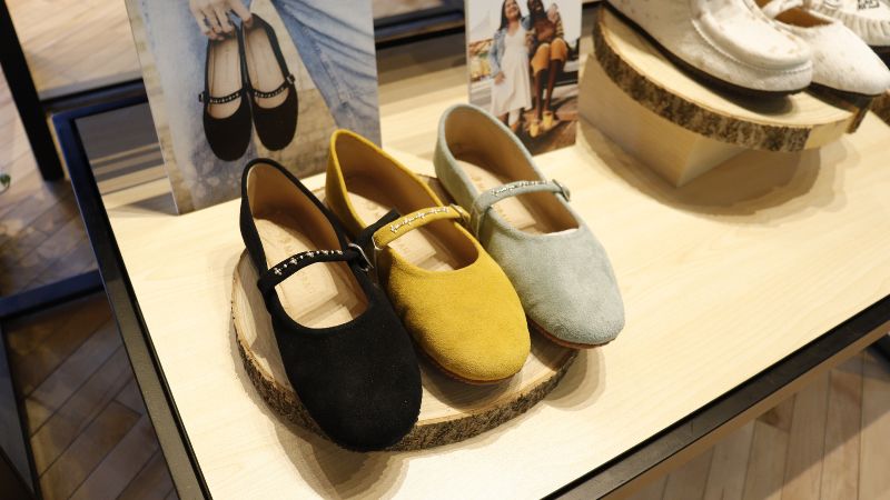 A line of three Mary Jane shoes in different colours.